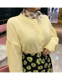 Eleganter karierter Seidenschal kombiniert mit gelber Strickjacke für Damenmode.