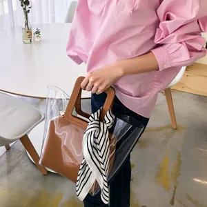 Schwarz-weißer gestreifter Seidenschal kombiniert mit transparenter PVC Damentasche chic.