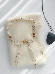 Vintage Pünktchen Seidentuch Halskette mit Holzperlen und Strickpullover Hintergrund.
