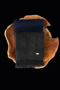 Detailaufnahme weicher Strick-Wollmischung Winter Schals in Marinegrau mit Metall-Logo.