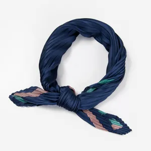 Detail view of the elegant pleated navy blue silk scarf with pink and green stripes.