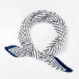 Detail view of a fashionable pleated square neck scarf with black and white chevron pattern.