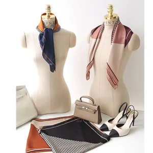 Detail view of stylish satin square scarf with geometric stripes and heart pattern design.