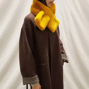 Détail en gros plan de l'écharpe d'hiver en peluche jaune vif montrant texture et confort.