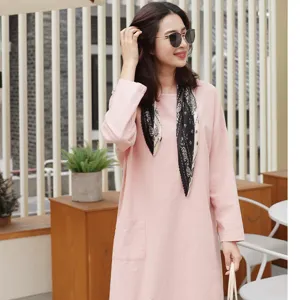 Detailansicht eines lässigen rosa Langarmkleids mit stilvollem schwarz-weißem Schal.