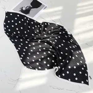 Detailed shot of black and white polka dot pleated silk scarf, elegant neckerchief decor.