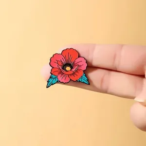 Close-up detail of the retro color-blocked red flower enamel pin, American tattoo style.