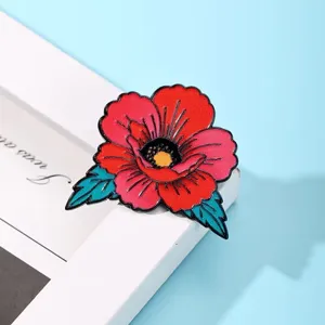 Detailed view of a retro color-blocked red flower enamel pin brooch, stylish clothing accessory.