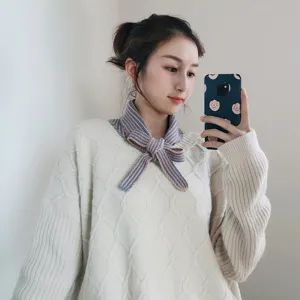 Knitted striped mini scarf, blue and pink color block bow design, stylish neck accessory detail.