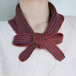 Detailed shot of a stylish knitted striped bow neck scarf, perfect for autumn and winter wear.