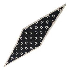 Detailansicht des schwarz-beigen Strick-Dreiecktuchs mit elegantem Monogramm-Muster.