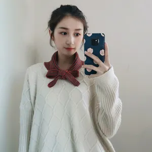 Knitted striped bow collar scarf detail, cozy winter accessory for women matching sweaters.