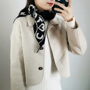 Knit mini scarf shawl detail view, showing soft texture, stylish black and white pattern.