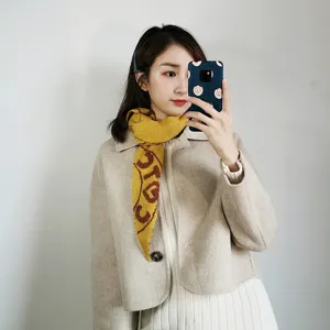 Knitted scarf detail view, elegant autumn winter warm neckwear accessory, soft fabric texture.