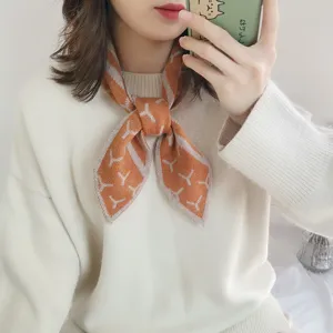 Nahansicht des orangefarbenen Strickhalstuchs mit geometrischem Muster, weich und warm.