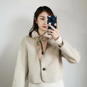 Detail view of women short winter coat and knit scarf set, elegant beige daily wear fashion.