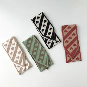 Nahaufnahme des Strick-Halstuchs mit niedlichem Herz-Muster und modischem Streifen-Design.