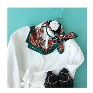 Inquadratura dettagliata di un elegante foulard in seta quadrata con stampa classica.
