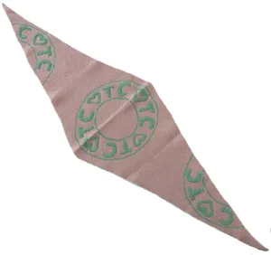 Close-up detail of a stylish pink knitted triangle scarf with green circular TC heart pattern.