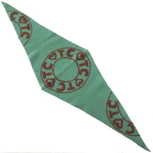Detailed view of green knitted triangle scarf with brown letter and heart knit patterns.