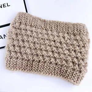 Beige gebreide oorbeschermer hoofdband detailweergave, dik winter haartoebehoor.