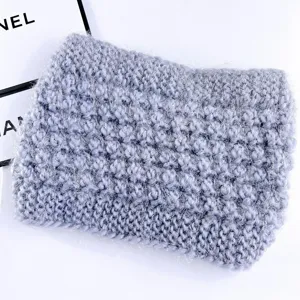 Detailopname van de grijze pluizige gebreide winter oorwarmer haarband zachte textuur.