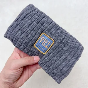 Detailed view of the dark gray knitted hair band with embroidered patch for daily wear.