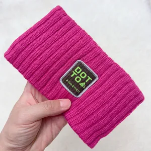 Close-up detail of hot pink ribbed knitted hair band with patch, soft and stylish.