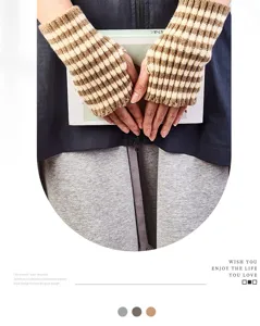 Close up detail of cozy brown and white striped fingerless knit gloves for autumn and winter.