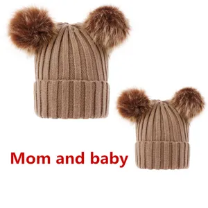 Mom and baby matching winter knitted beanies with double faux fur pom poms, warm cozy hats.