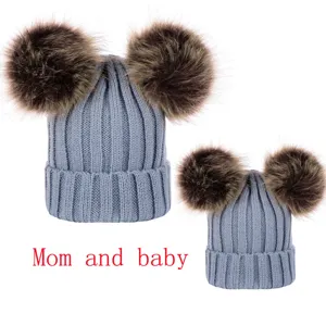 Close up view of the cozy knit parent child matching double pom pom beanie hat detail