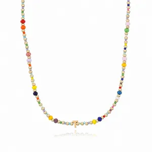 Detailed close-up of bohemian colorful rice bead necklace featuring a gold letter T pendant.