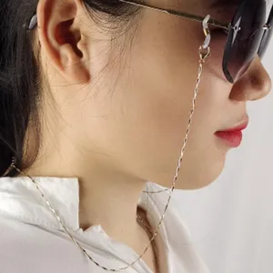 Dettaglio squisito della catena per occhiali in metallo, elegante finitura dorata con anelli.
