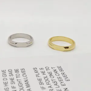 Primo piano di anelli in metallo minimalisti color argento e oro con finitura lucida.