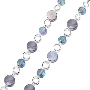 Primo piano dettaglio catenella per occhiali in argento con cristalli iridescenti e dischi.