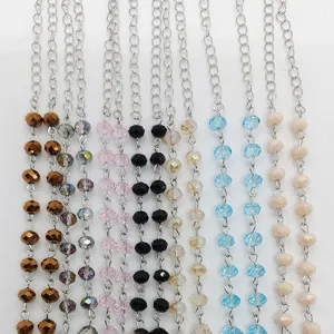 Primo piano dettagliato di catenine di perle in vetro cristallo colorate e maglie argentate.