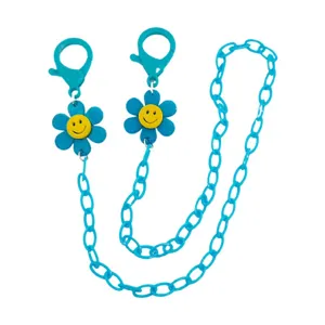 Gedetailleerde close-up van de blauwe acryl ketting met gele smiley bloemhangers.