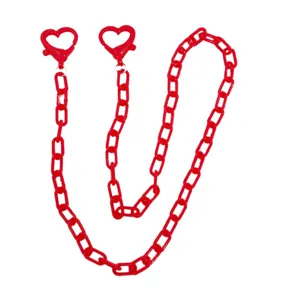 Dettaglio catena con chiusura a cuore in acrilico rosso con maglie e moschettone