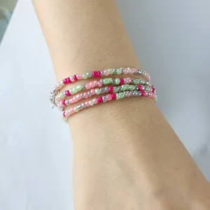 Detailed shot of a multi-strand colorful seed bead bracelet showcasing vibrant pink and green beads.