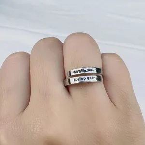 Primo piano dettaglio dell anello doppio in acciaio inossidabile regolabile inciso con scritta.