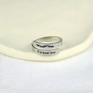 Primo piano dettaglio dell'anello doppio regolabile in acciaio inox con incisione floreale.