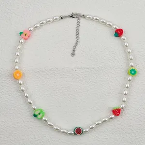 Dettaglio in primo piano della collana di perle boho con ciondoli di frutta in argilla polimerica.