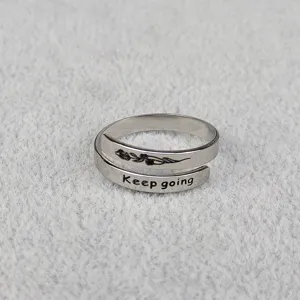 Primo piano dettaglio di anello regolabile in acciaio inossidabile argento con incisione.