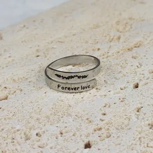 Anello doppio regolabile in acciaio inossidabile con incisione foglia e dettaglio testo.