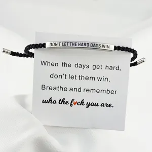 Bracciale intrecciato regolabile con barra in acciaio inox inciso e carta motivazionale.