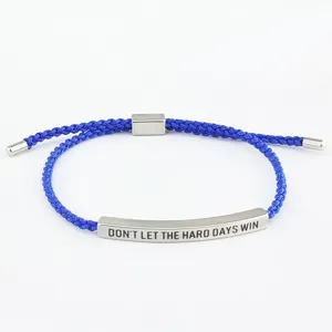 Primo piano dettagliato del bracciale in corda intrecciata blu con barra in acciaio.