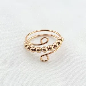 Nahaufnahme Detail des roségoldenen Titanstahl Fidget Rings mit beweglichen Perlen.