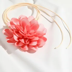 Primo piano dettagliato della collana girocollo con fiore in tessuto rosa e delicati petali strati.
