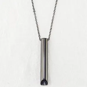 Primo piano del ciondolo per collana di respirazione in acciaio inossidabile dal design scuro elegante.