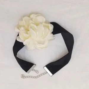 Elegante collana choker in velluto nero con un grande fiore di camelia in tessuto bianco.